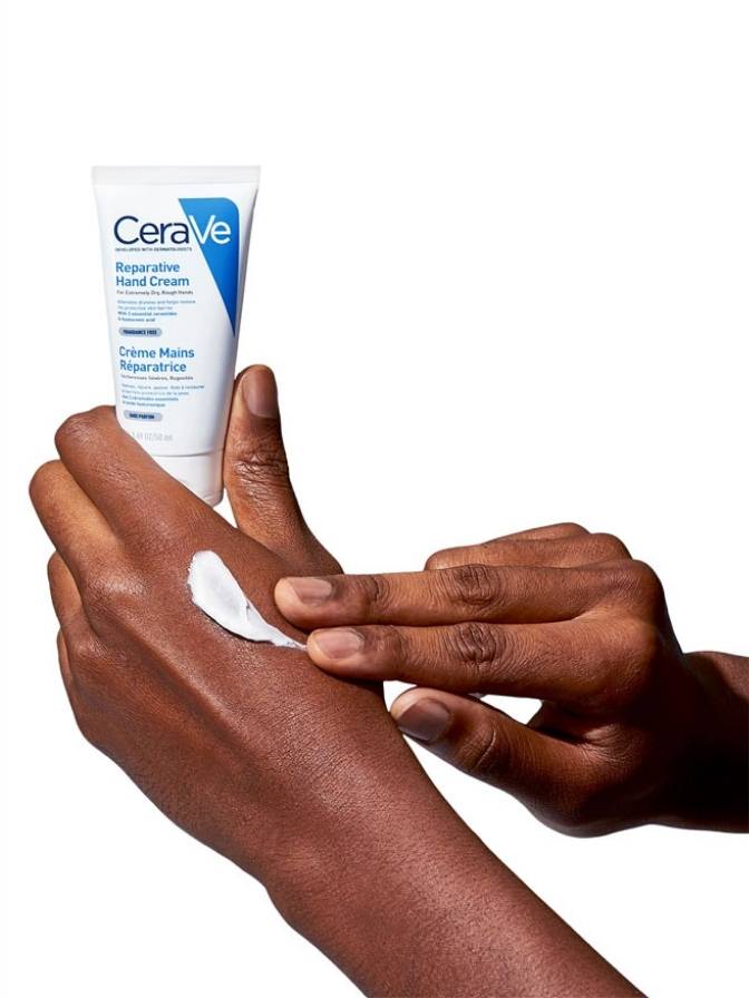 CeraVe hand cream being applied to a hand on a white background