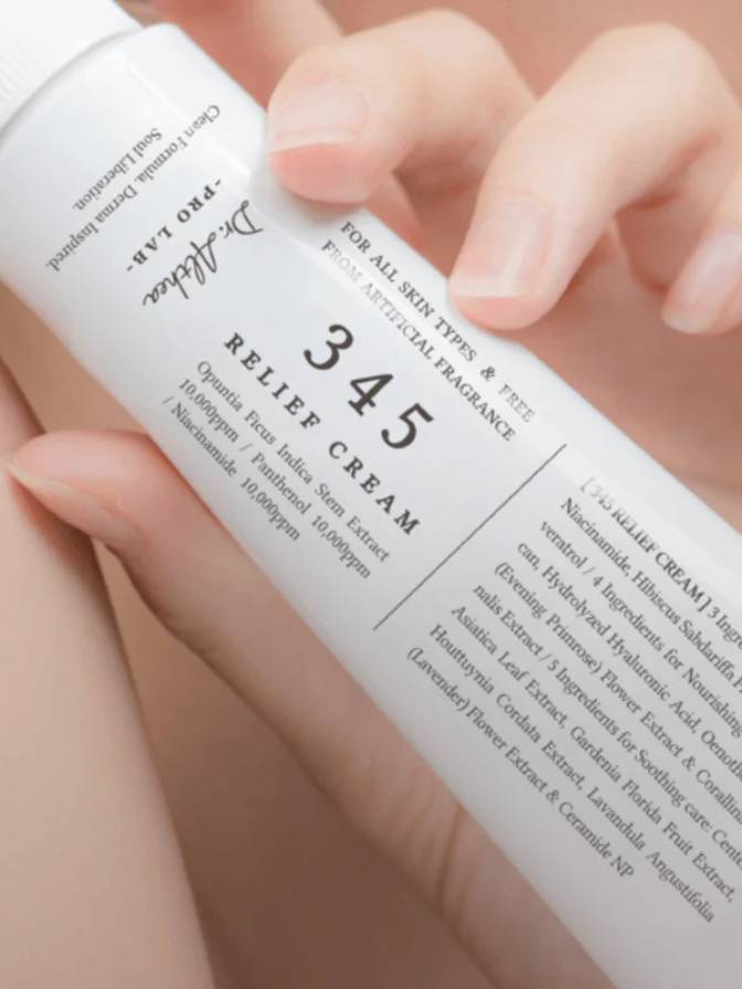 Hand holding a bottle of '345 Relief Cream' with a focus on the label.
