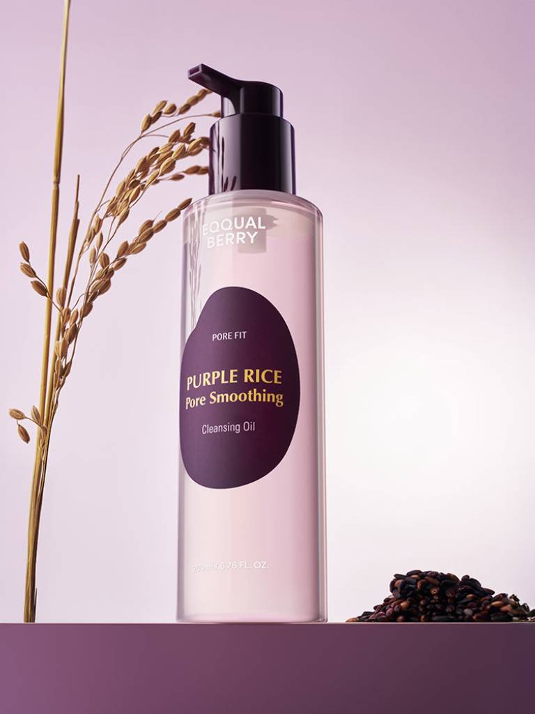 Skincare bottle labeled 'Purple Rice' on a purple background with a plant and rice grains.