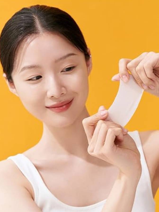 Woman holding a white strip against an orange background