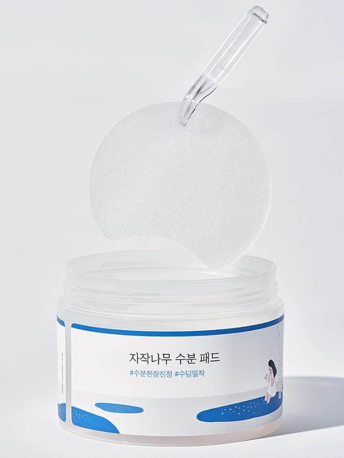 Skincare product jar with a dropper on a light gray background