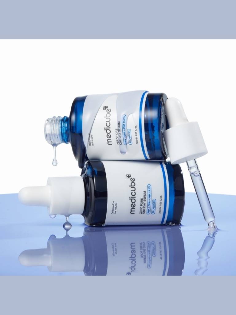 Two skincare bottles with droppers on a reflective surface
