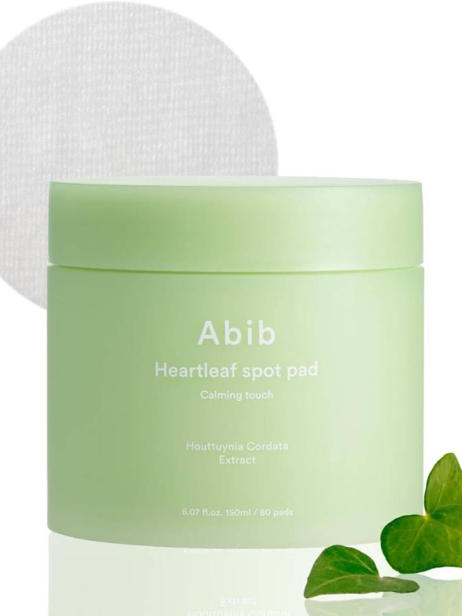 Green container of Abib Heartleaf spot pad with a white applicator on a light background