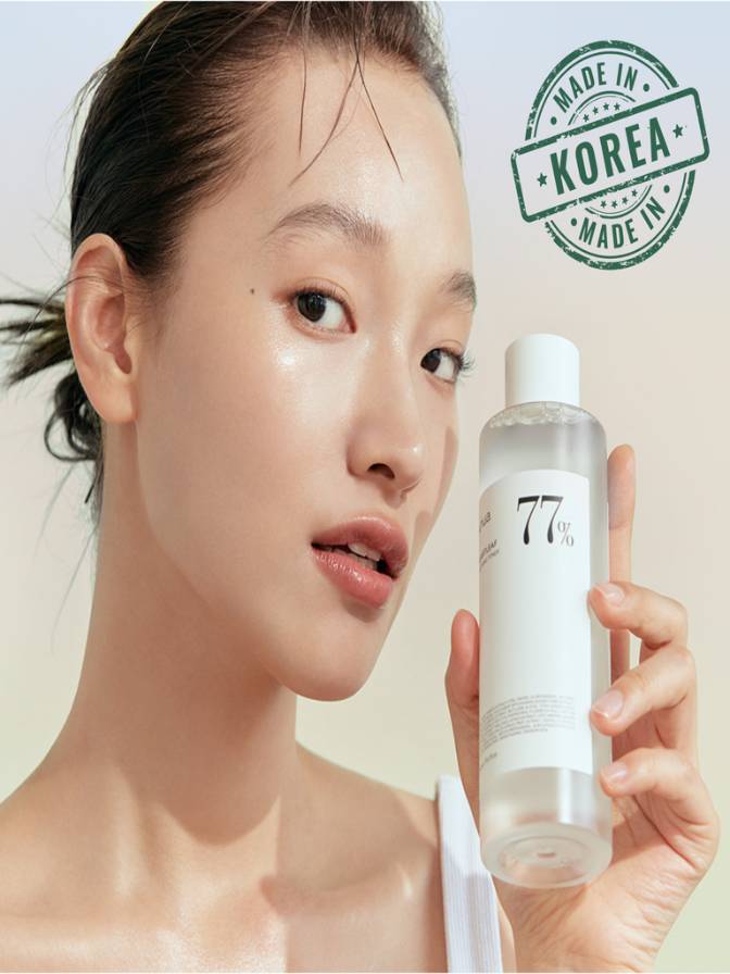 Woman holding a skincare product with 'Made in Korea' stamp