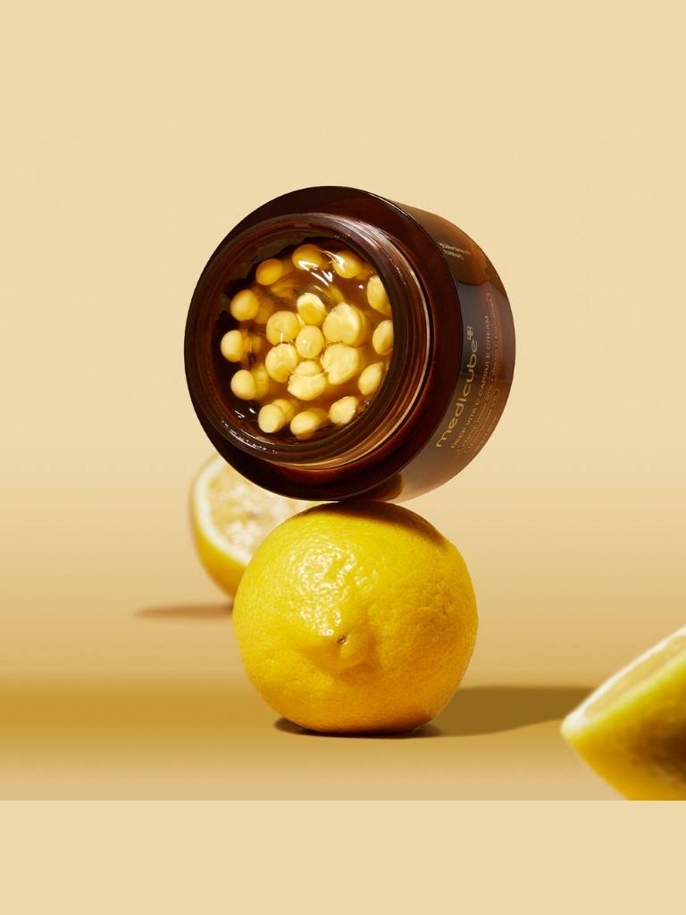 Jar of cosmetic product with lemons on a beige background