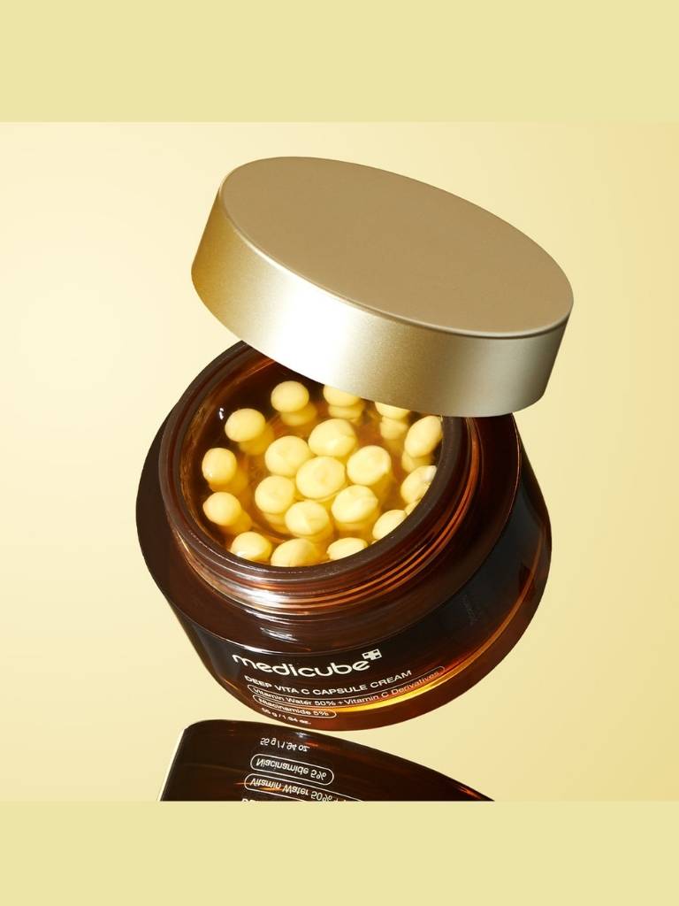 Jar of capsules with a gold lid on a beige background, featuring the brand 'medicube'.