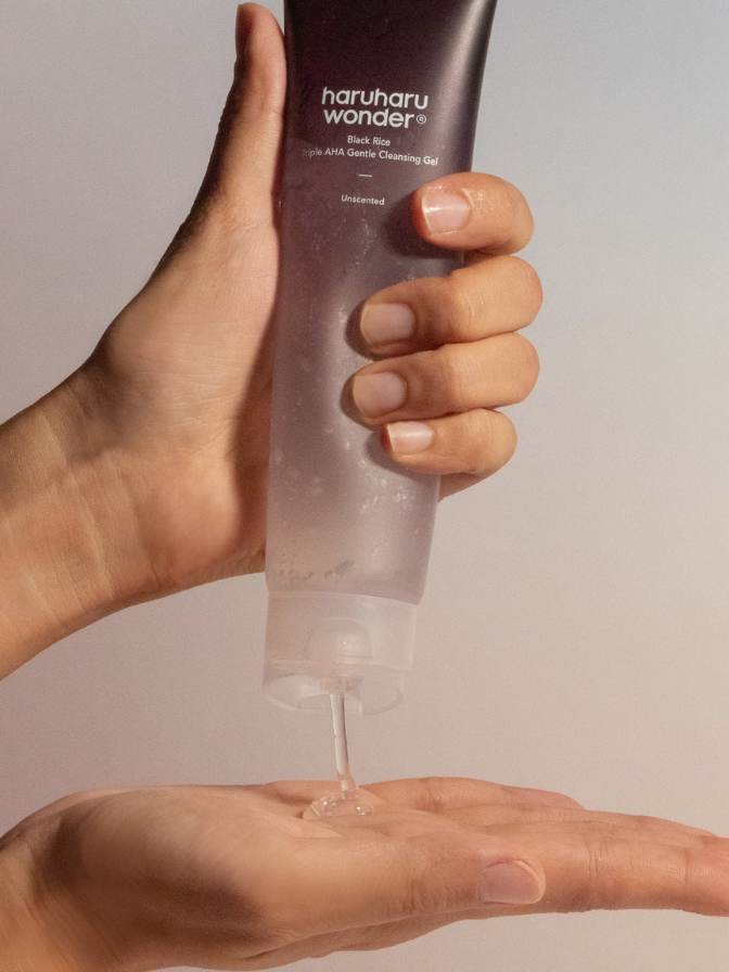 Hand holding a tube of haruharu wonder Unscented product against a neutral background