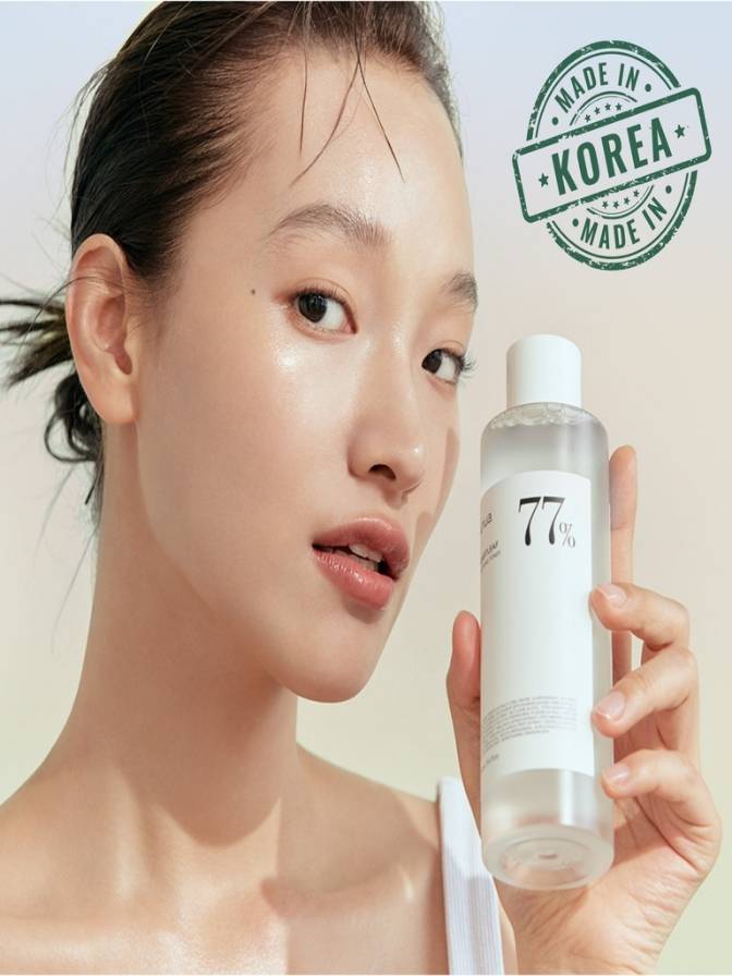 Woman holding a skincare product with 'Made in Korea' stamp
