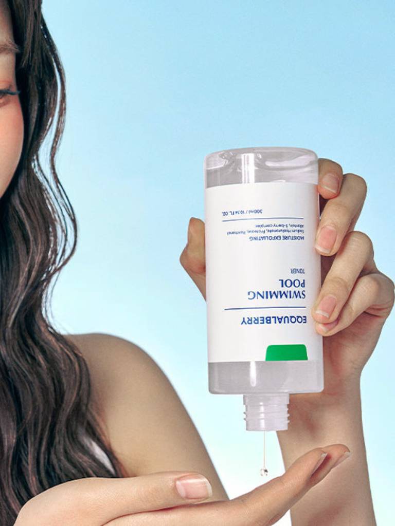 Person holding a skincare product with a blue background