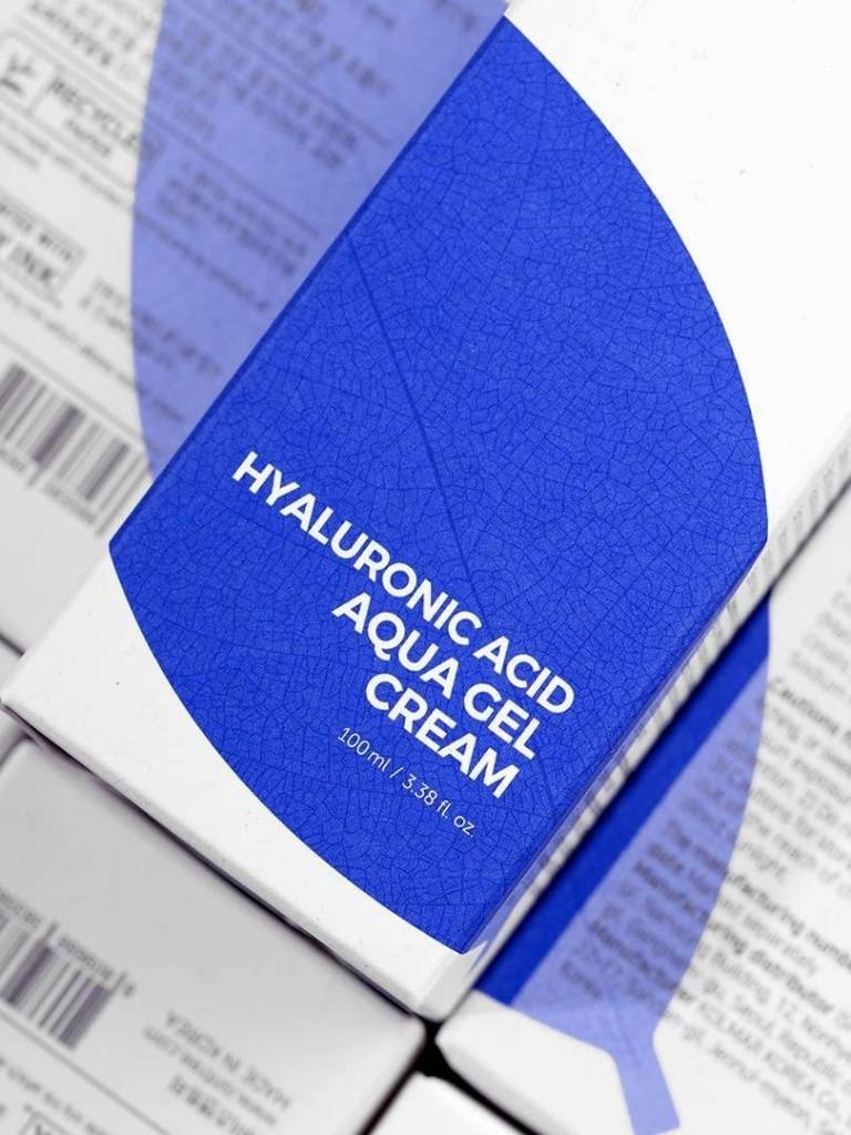 Hyaluronic Acid Aqua Gel Cream packaging with blue and white design on a newspaper background