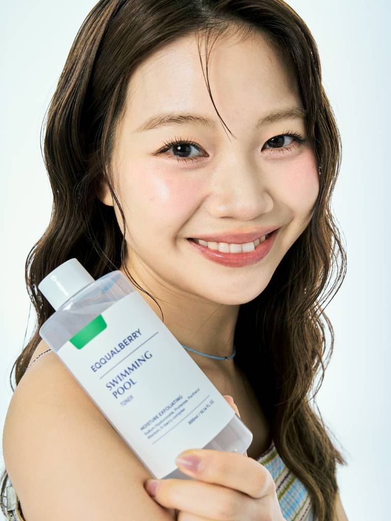 Woman holding a bottle of Equisense Equalberry product against a white background