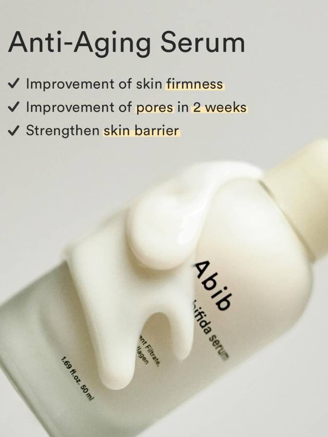 Anti-aging serum bottle with text highlighting benefits on a light gray background
