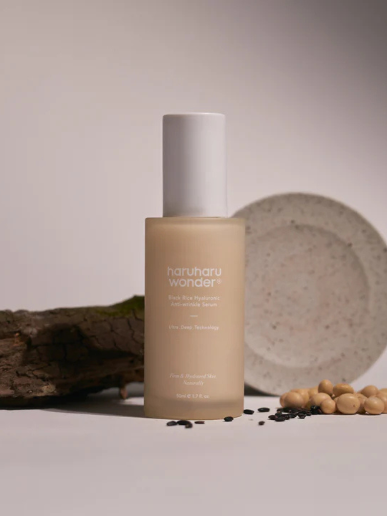 Skincare bottle labeled 'Nourish & Wonder' on a neutral background with natural elements.