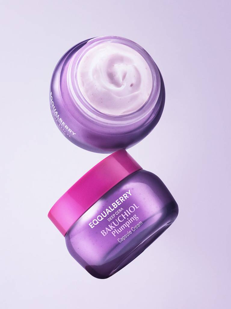Two purple skincare jars with white cream on a light purple background