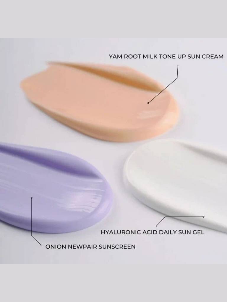 Three sun care products labeled 'Yam Root Milk Tone Up Sun Cream', 'Hyaluronic Acid Daily Sun Gel', and 'Onion Newpair Sunscreen' on a light gray background.