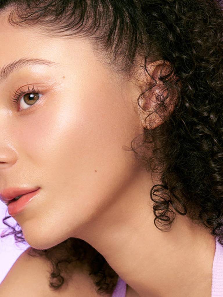 Close-up of a person with curly hair and a light skin tone.