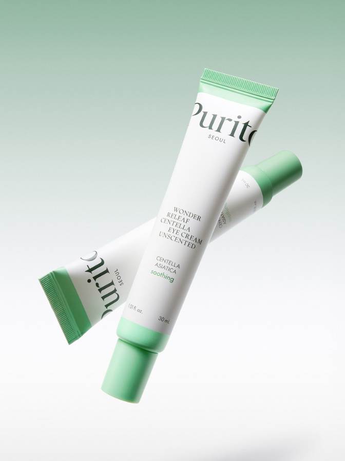Two tubes of Purito skincare cream on a light green background