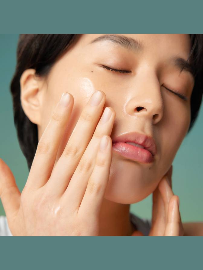 Person applying cream to their face with a blurred background