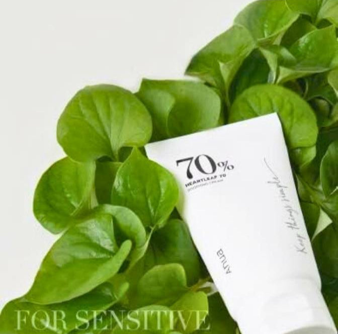 White tube of cream with green leaves on a white background