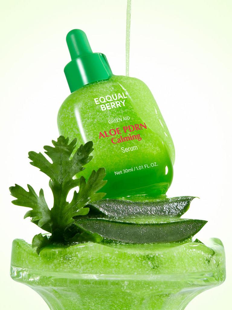 Green aloe vera serum bottle with leaves on a white background