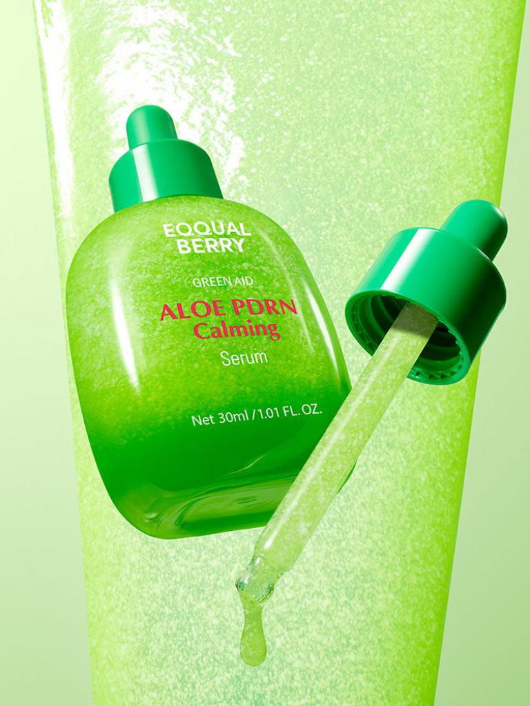 Green aloe vera serum bottle with dropper on a green background
