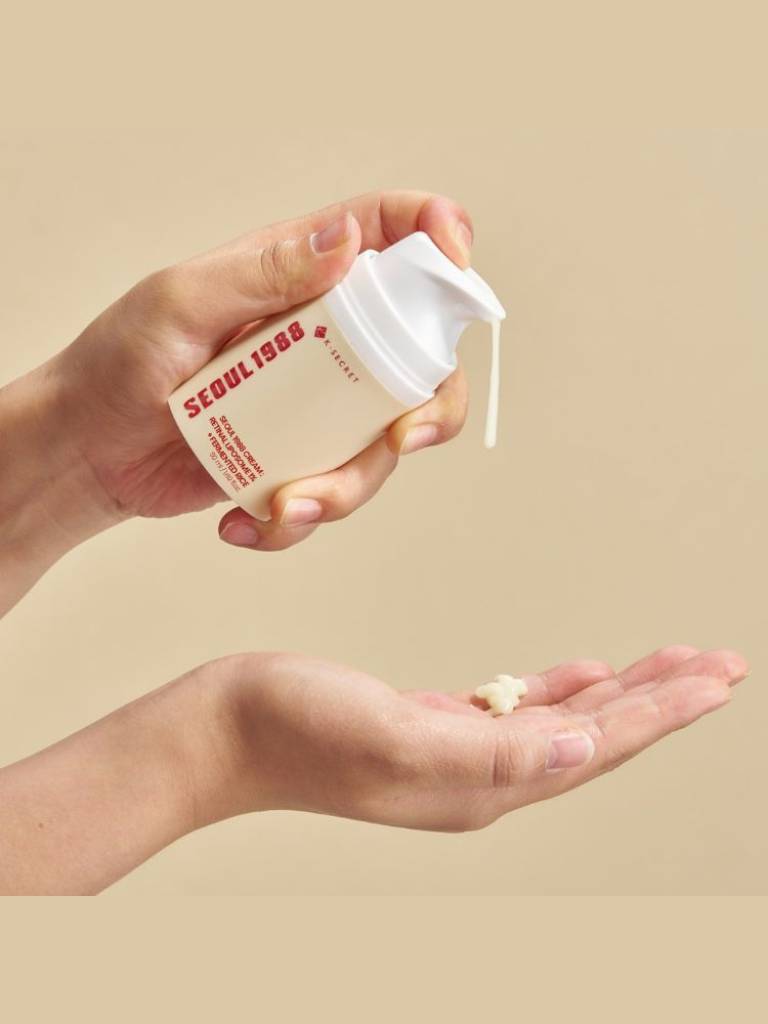 Hand holding a small container labeled 'Seoul 1968' with a beige background