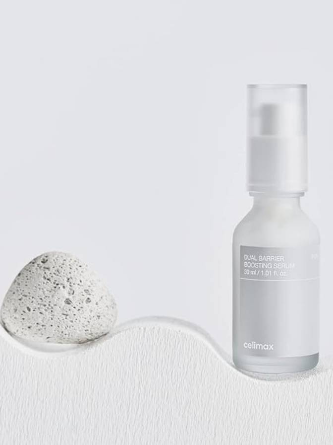Skincare bottle and pumice stone on a white background