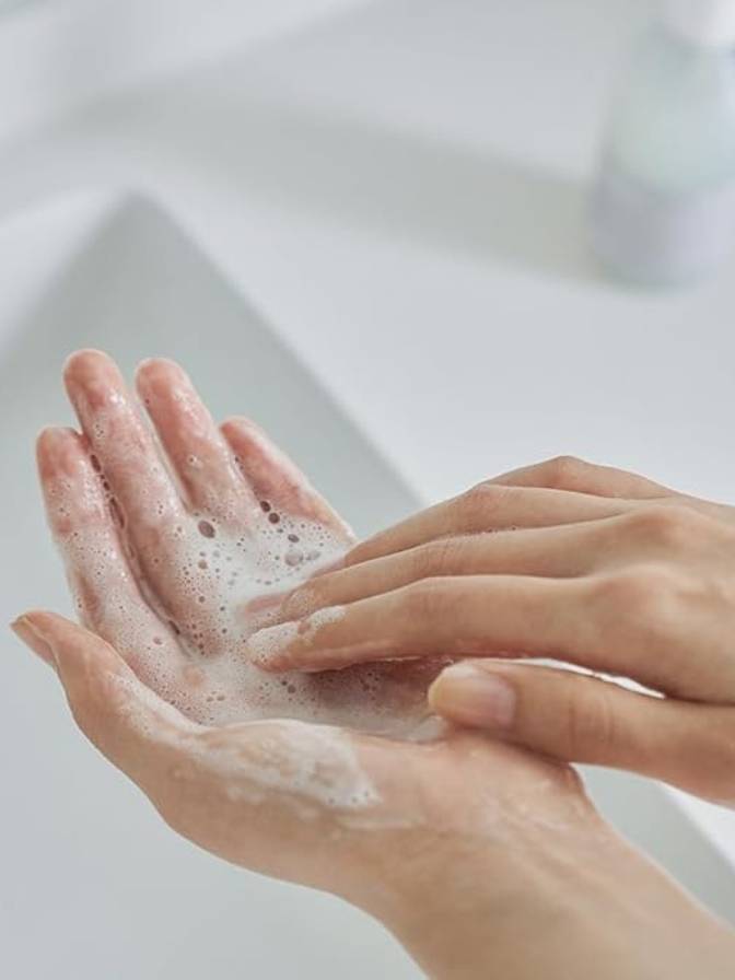 Hands with soap bubbles against a blurred background
