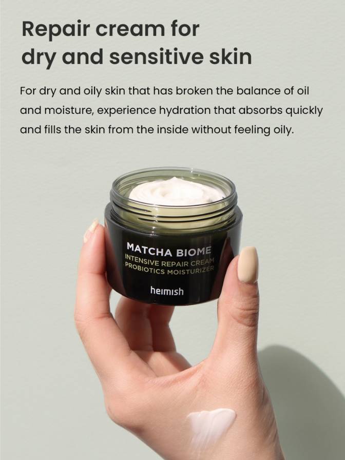 Hand holding a jar of 'Matcha Biome' repair cream with text about skin care on a gray background