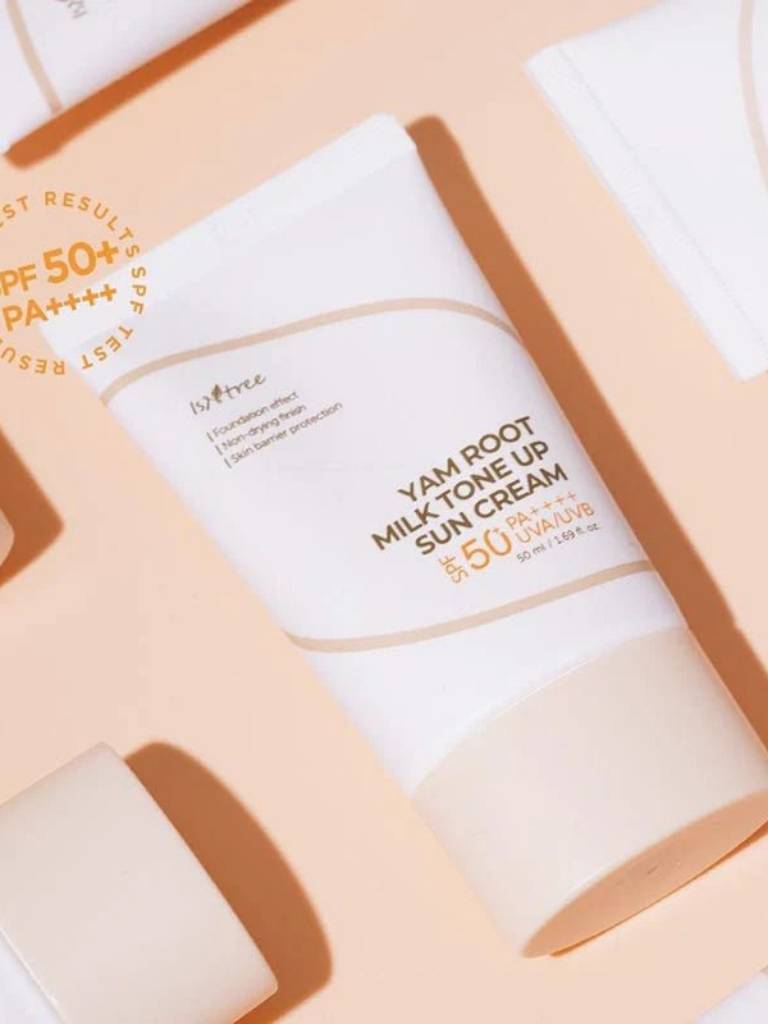 Yam Root Milk Tone Up Sun Cream with SPF 50+ on a beige background