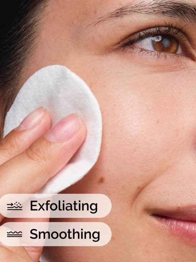 Person using a cotton pad on their face with exfoliating and smoothing text.