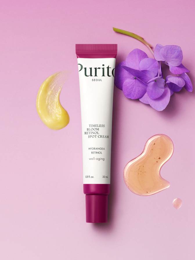 Purito skincare cream tube with purple flowers and cream swatches on a pink background