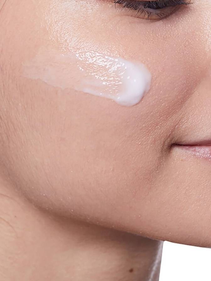 Close-up of a person applying cream to their face