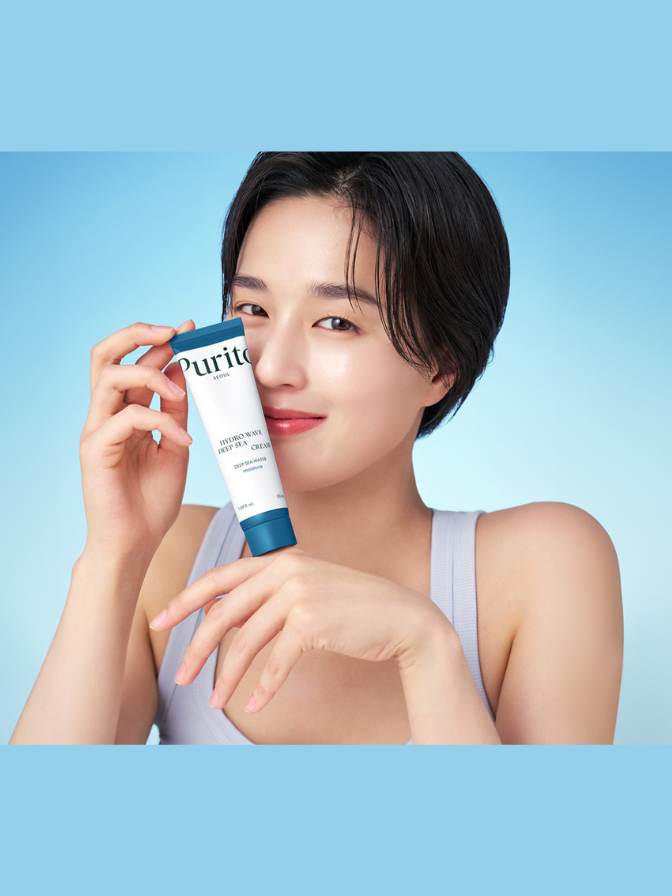 Woman holding a Purito skincare product against a blue background