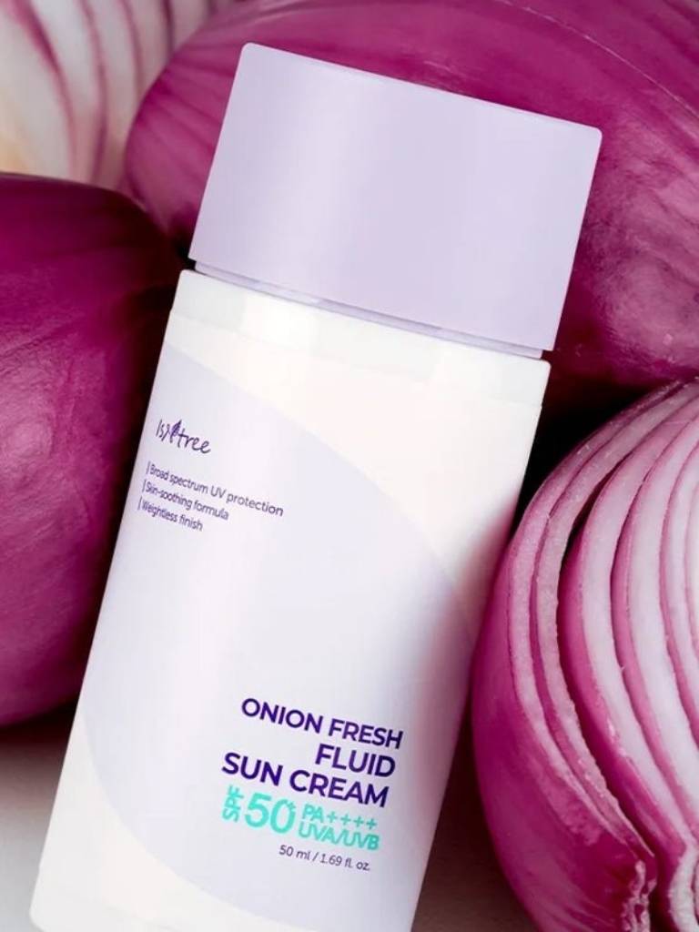 Sun cream bottle labeled 'Onion Fresh Fluid Sun Cream' with purple onions in the background