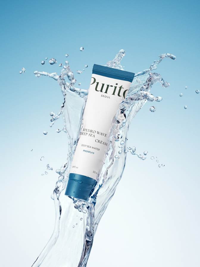 Purito skincare product with water splash on a light blue background