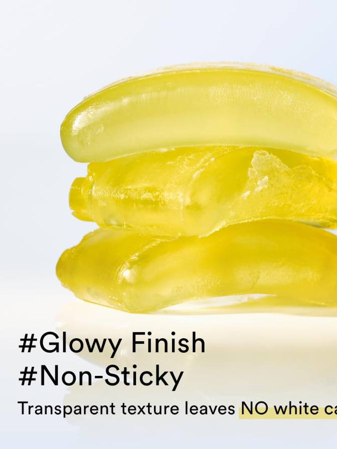 Yellow gel-like substance with text 'Glowy Finish', 'Non-Sticky', and 'Transparent texture leaves NO white cake'.