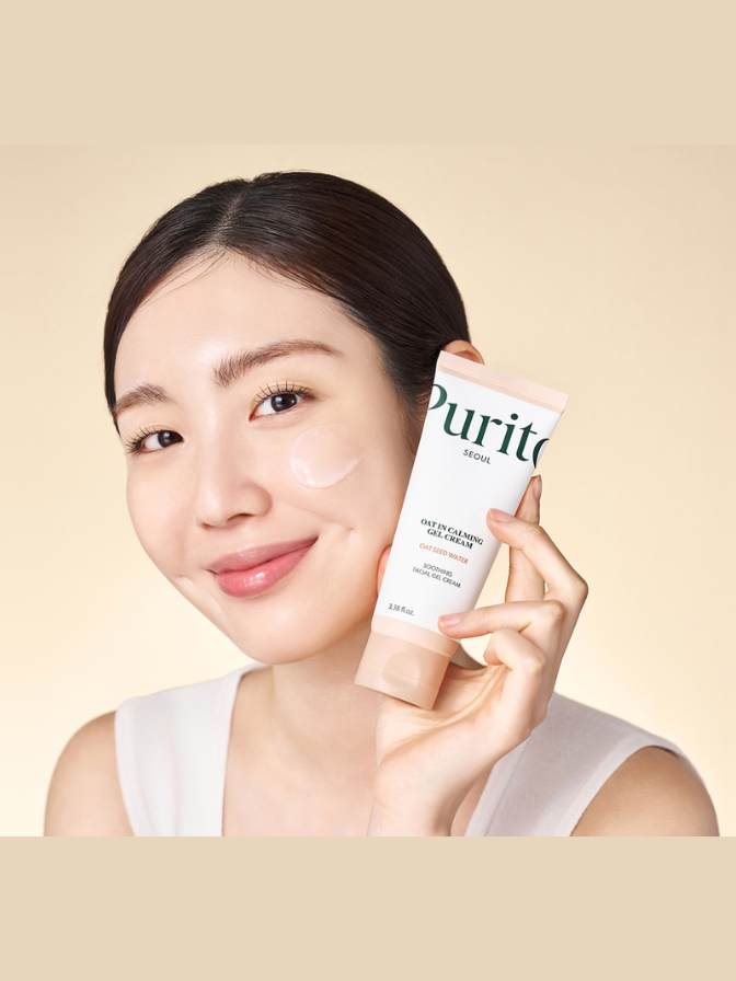 Woman holding a skincare product with 'Purito' branding against a beige background