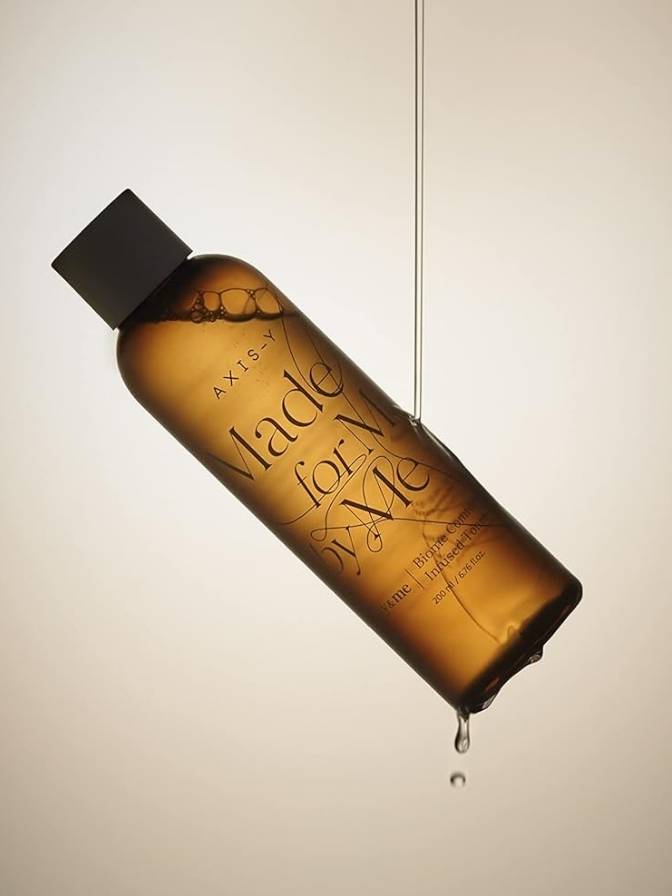 Brown bottle with black cap labeled 'Made for Me' on a beige background