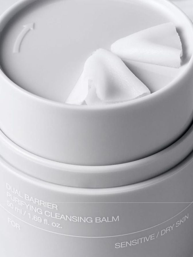Cleansing balm in a white container with visible text on a white background
