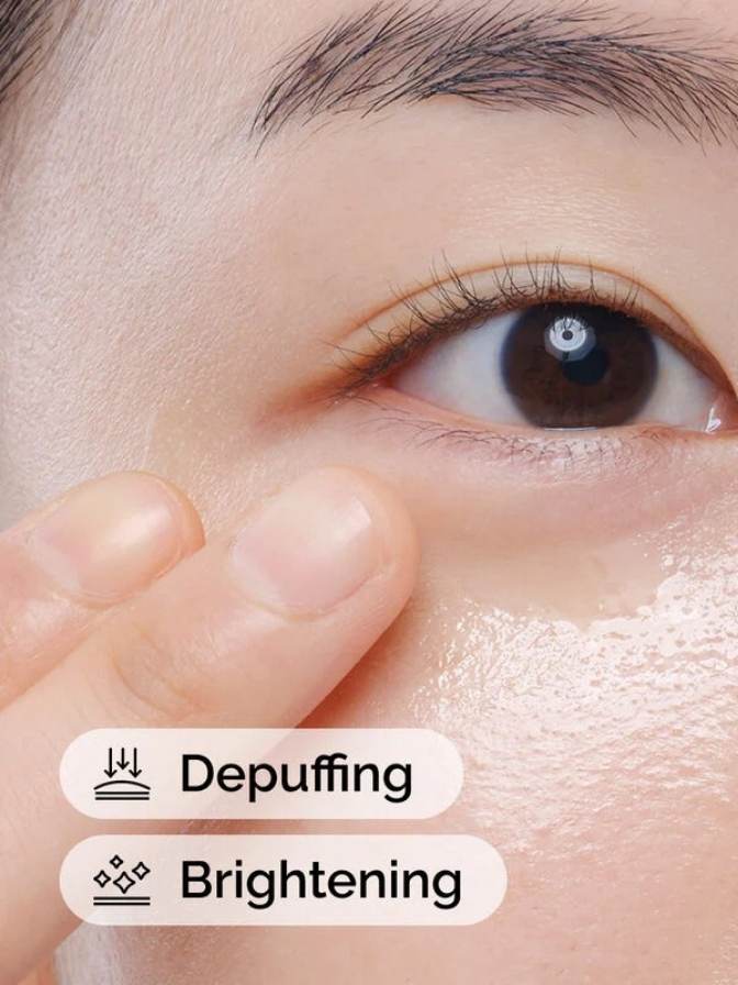 Close-up of a person's eye with text indicating depuffing and brightening effects.