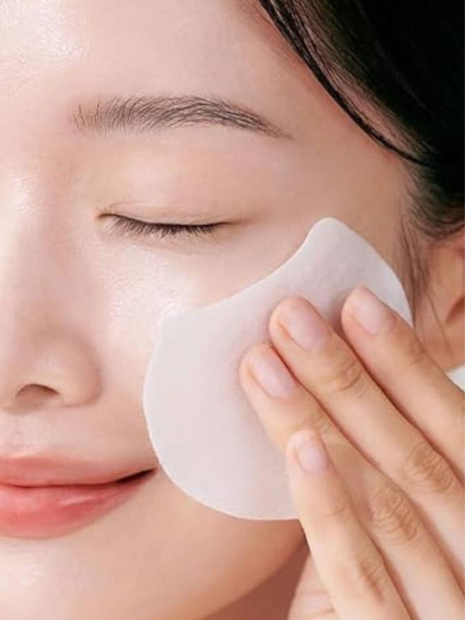 Person applying a white patch to their face with a hand