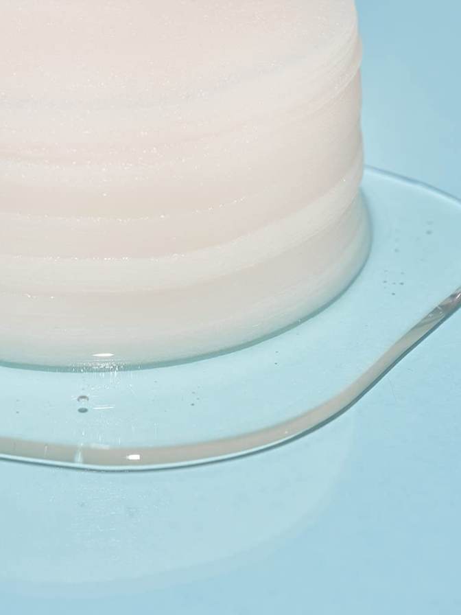 Close-up of a pink cake on a white plate with a light blue background
