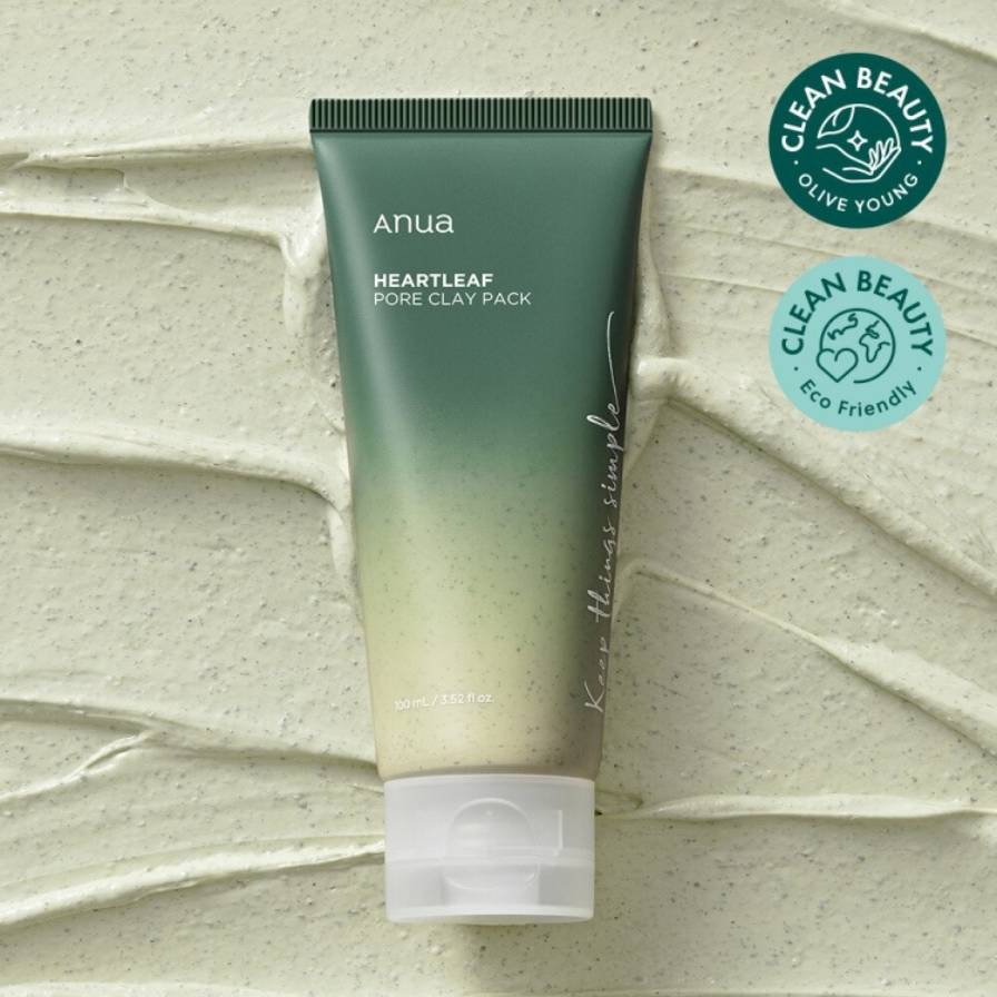 Green tube of 'anua' Heartleaf Pore Clay Pack on a textured beige background with 'Clean Beauty' logos.